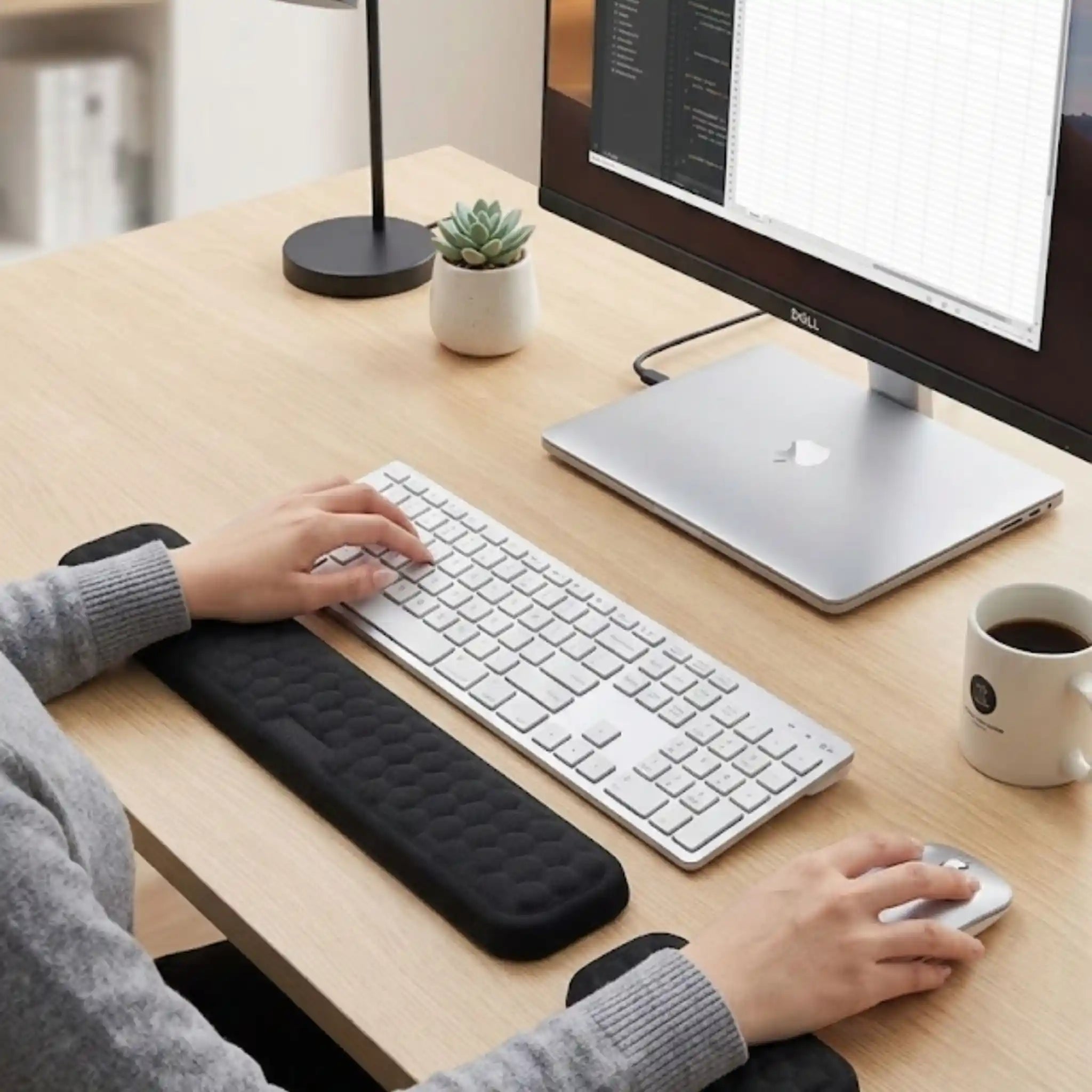 A professional working comfortably at a desk utilizing the RelievoCare Memory Foam Wrist Rest Set.